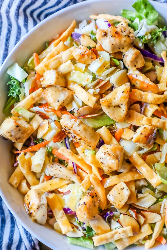 delicious chicken Asian salad in a white bowl with a striped towel in the background