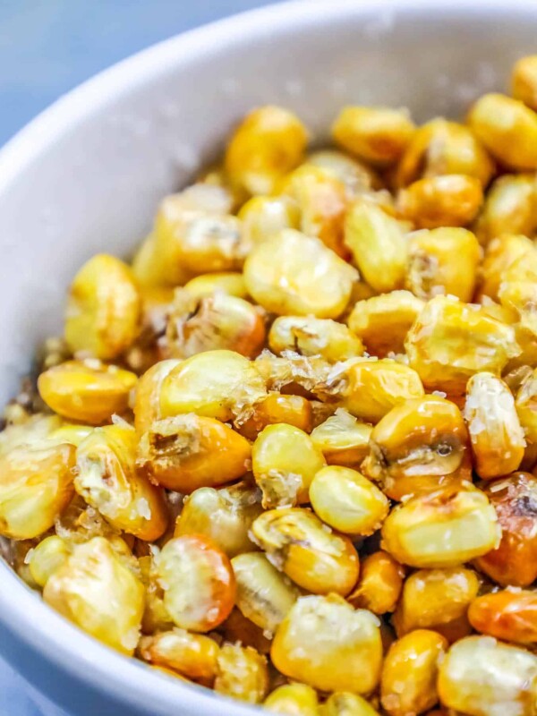 Homemade roasted corn in a white bowl.