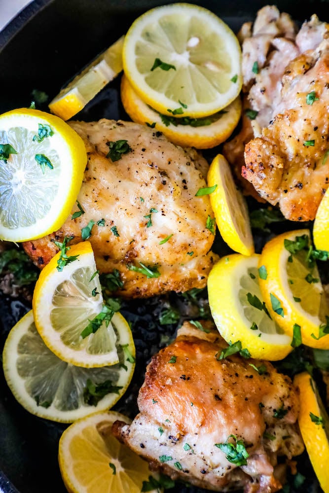 Chicken thighs in a pan with lemons