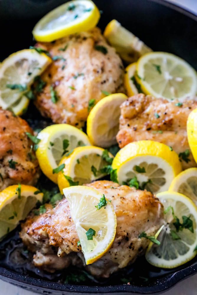 sliced lemons in a pan with chicken thighs