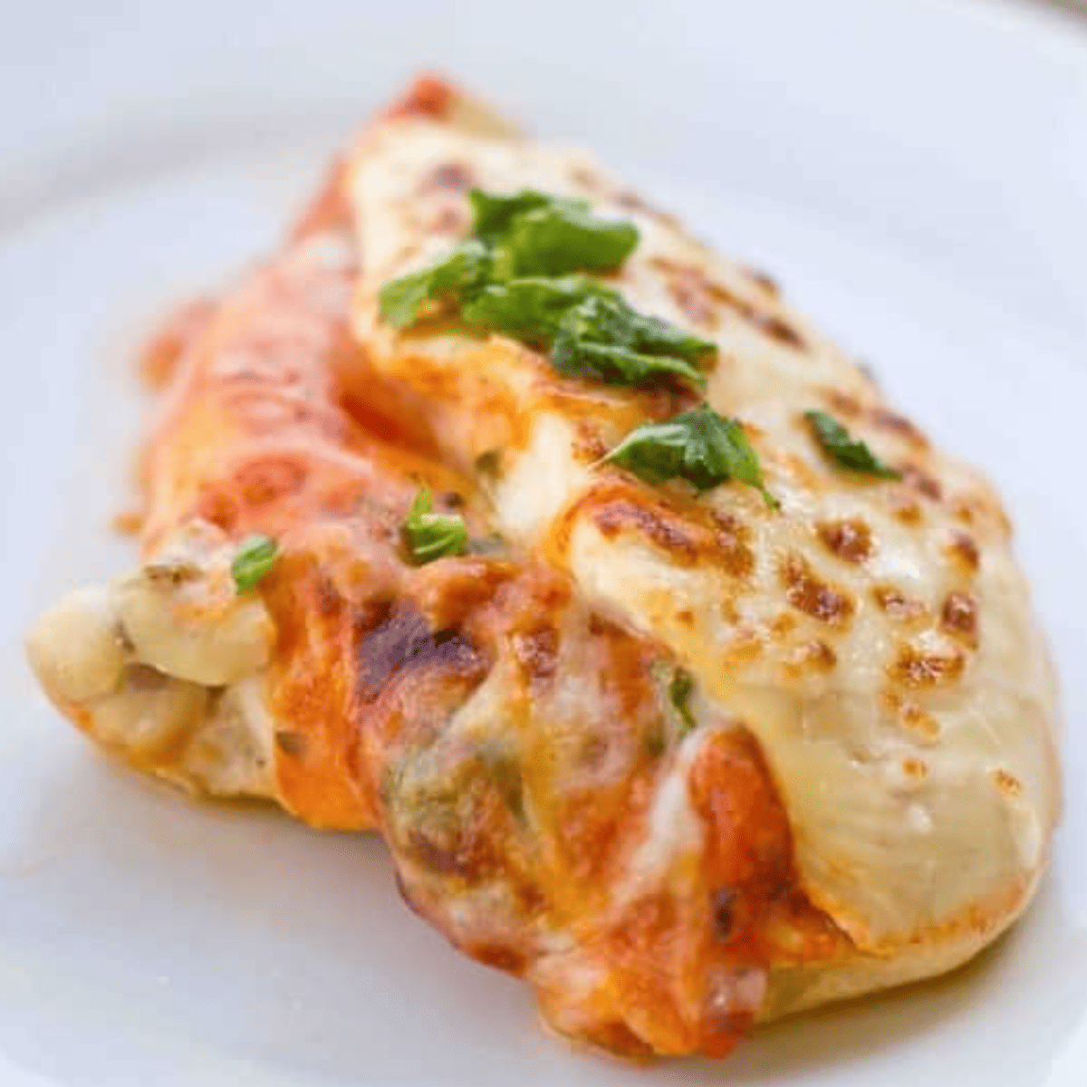 A close up of baked chicken parmesan with melted cheese.