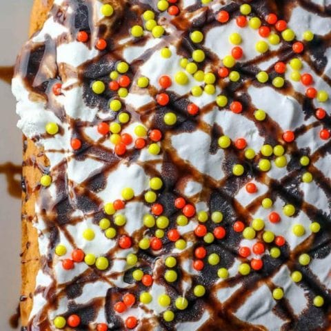 A cake with sprinkles and icing, made with an easy pumpkin dump cake recipe.