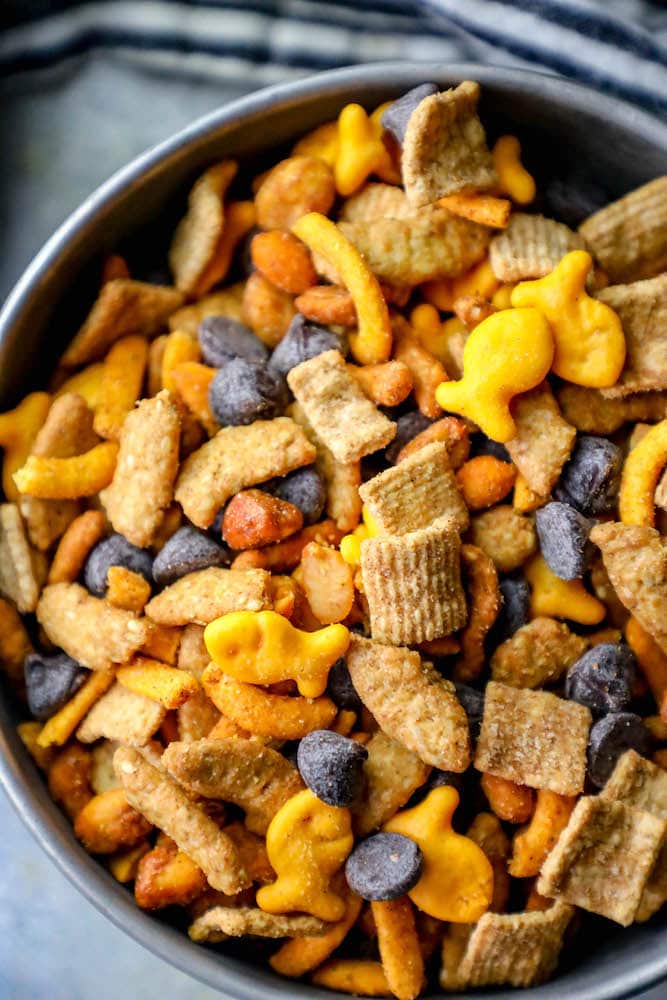 picture of guinness snack mix with goldfish crackers, graham crackers, chocolate chips, sesame sticks, and spicy trail mix in a metal bowl