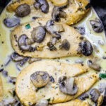 Chicken breasts with mushrooms in a creamy sauce, garnished with herbs, cooked to perfection for an easy low carb slow cooker creamy chicken marsala.