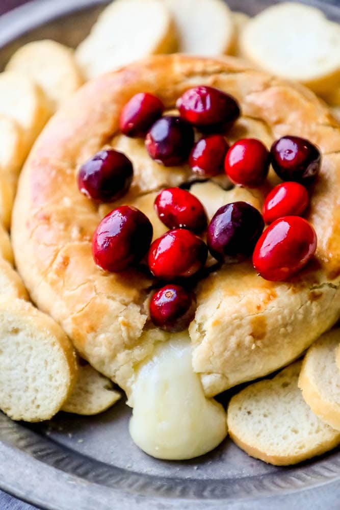 braked brie with cranberries on top, some cheese coming out. 