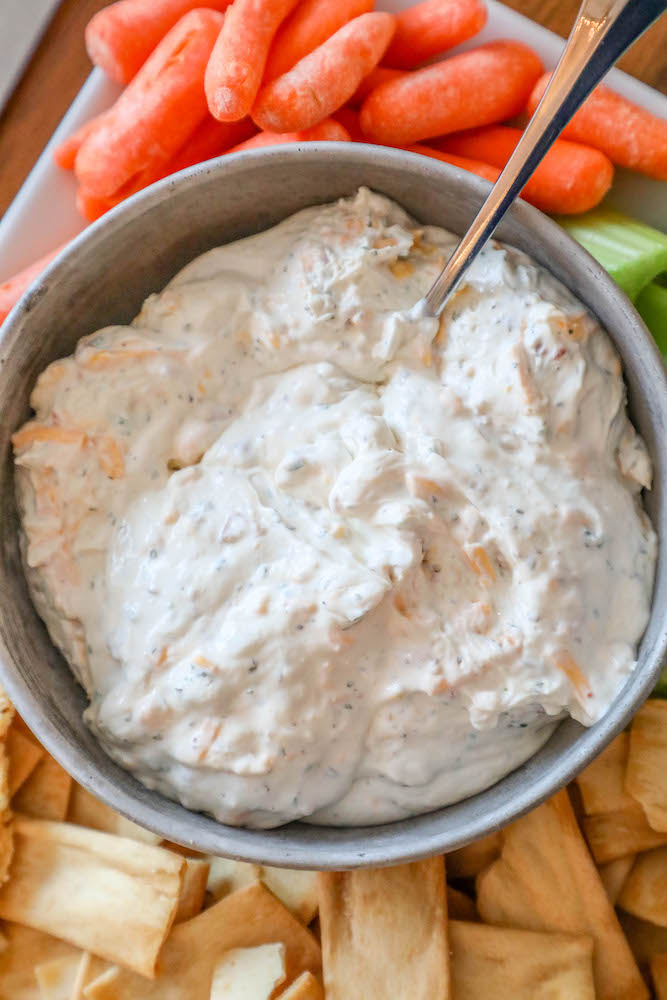 creamy dip with carrots, celery, and crackers around it