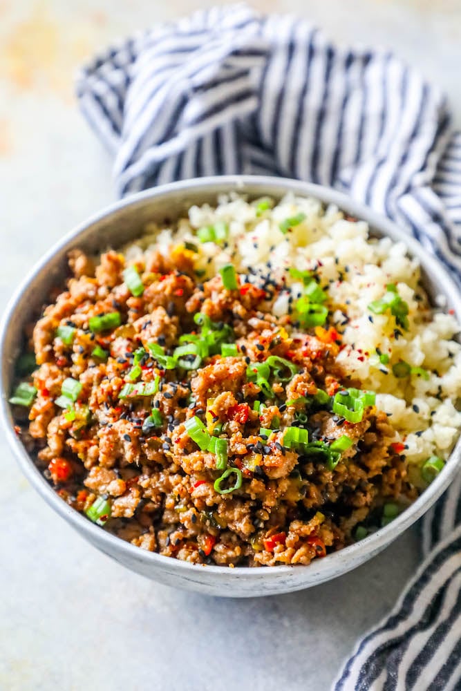 a bowl with rice, ground turkey, and green onions on it