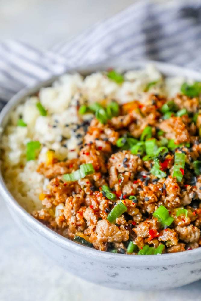 a bowl with rice, ground turkey, and green onions on it