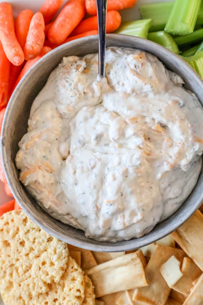 creamy dip with carrots, celery, and crackers around it