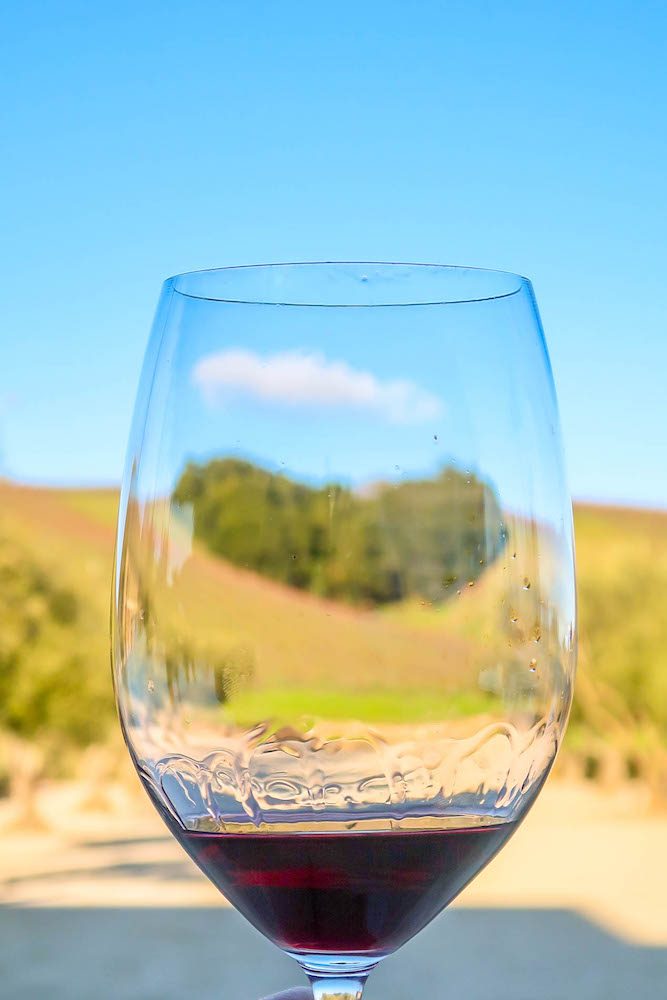 wine glass with hill shaped like heart in background