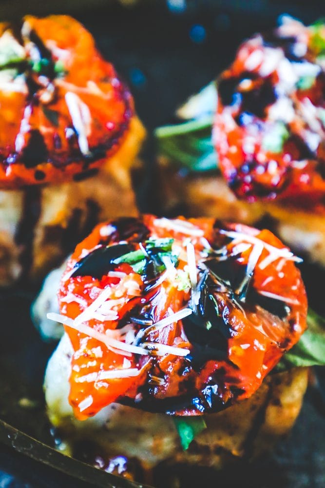 picture of three caprese chicken thighs in pan in oven 