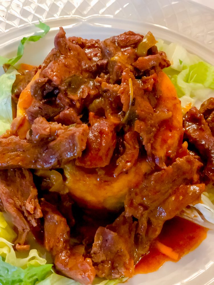 picture of beef mofongo in sauce on a white plate
