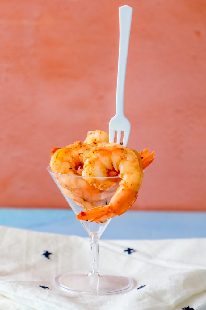 cajun seasoned shrimp in a cocktail glass with a fork in it