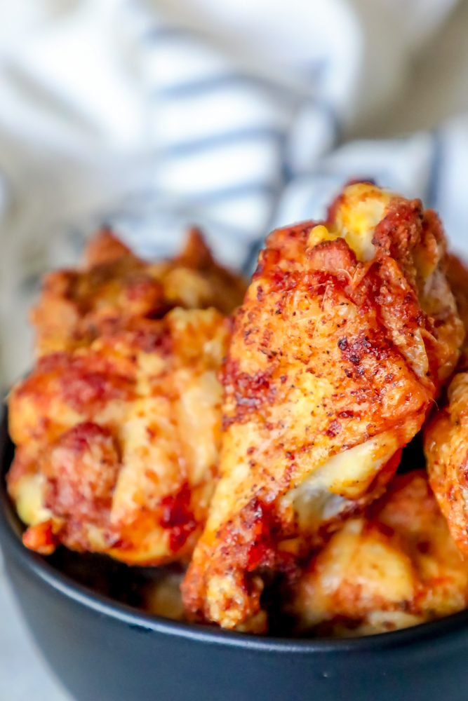 baked chicken wings piled together in a black bowl