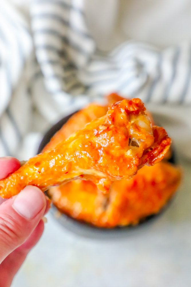 picture of hand holding a baked chicken wing