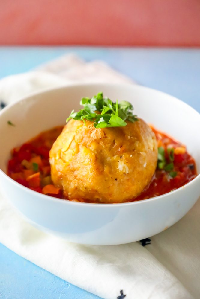 mofongo ball on top of creole sauce with chopped cilantro on top