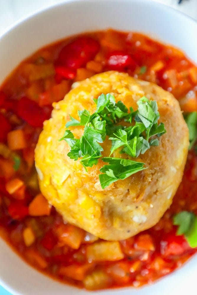 mofongo ball on top of creole sauce with chopped cilantro on top