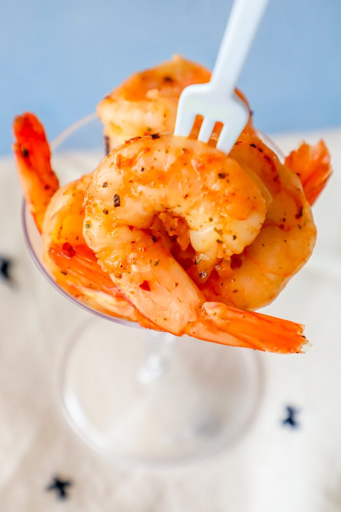 cajun seasoned shrimp in a cocktail glass with a fork in it