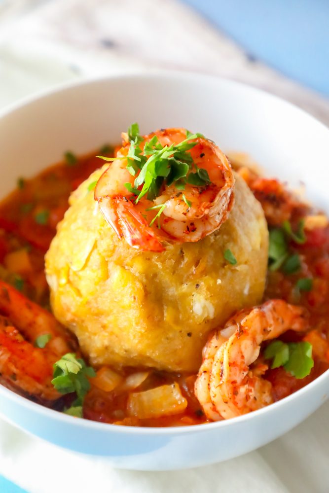A picture of a plantain mofongo with shrimp on top