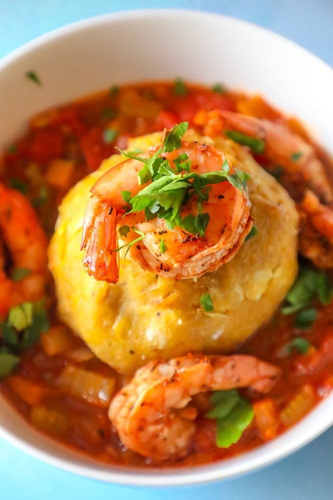 A picture of a shrimp on top of a bowl of creole shrimp mofongo
