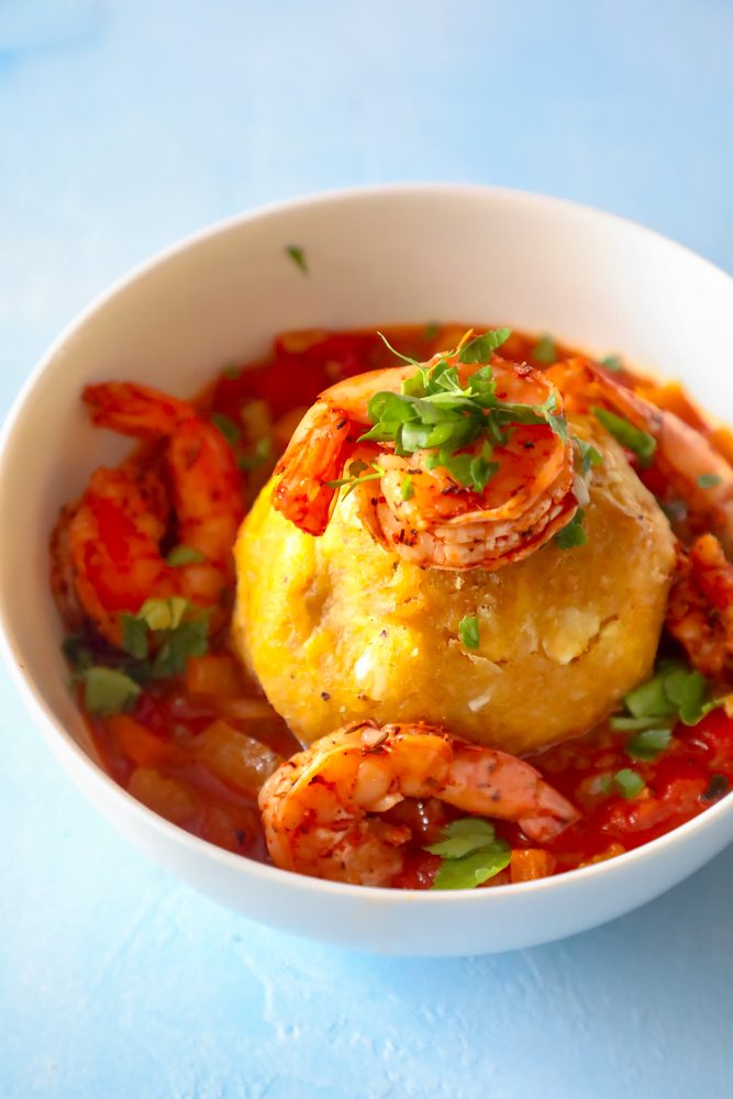 A picture of shrimp on top of a bowl of shrimp mofongo