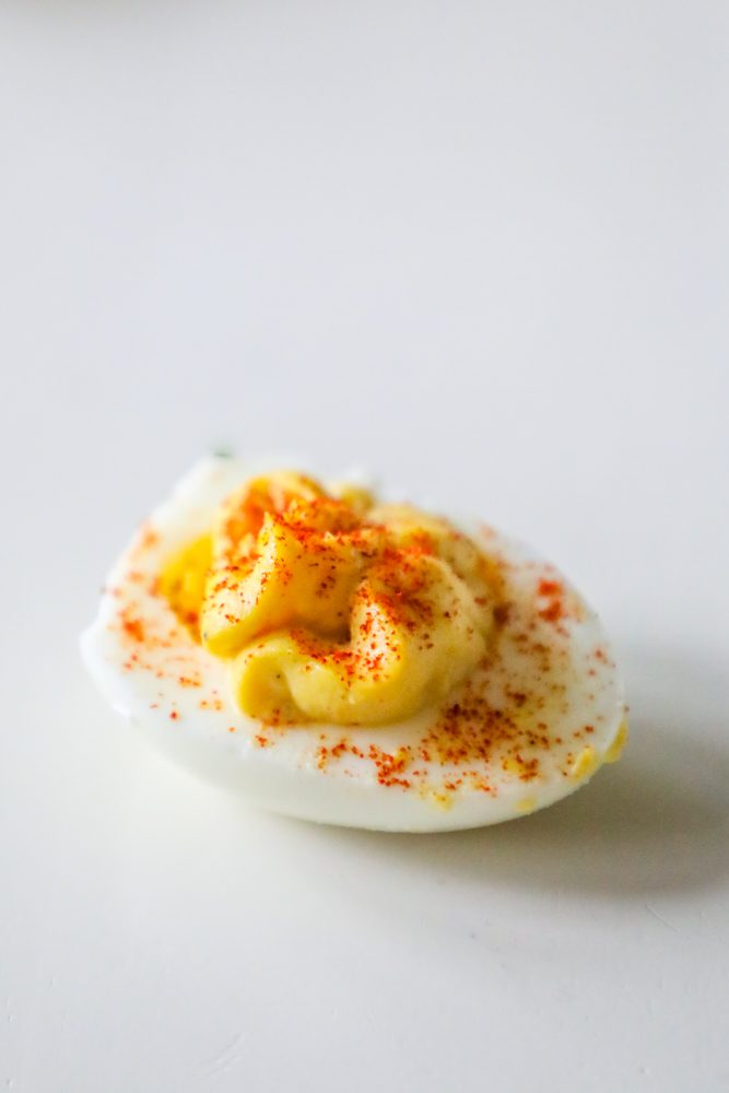 picture of deviled egg with paprika sprinkled on top on a table