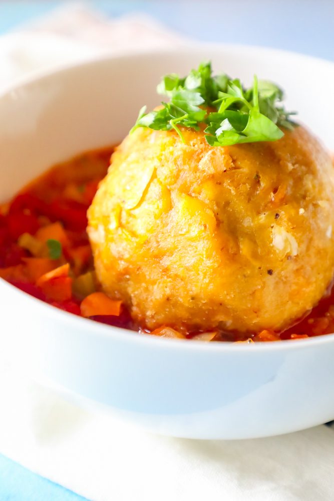 picture of mofongo ball on top of creole sauce with chopped cilantro on top