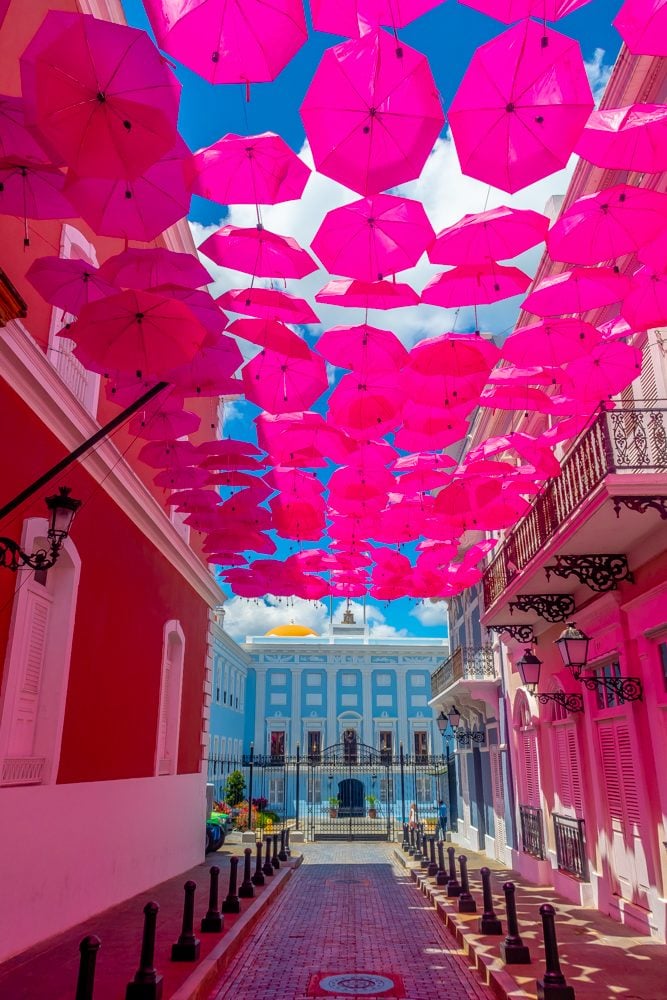 street in puerto rice with pink umbrellas over it