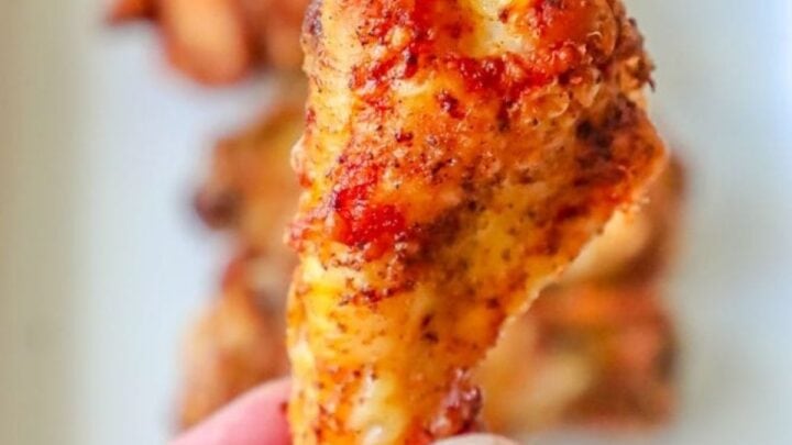picture of a hand holding baked cajun chicken wing