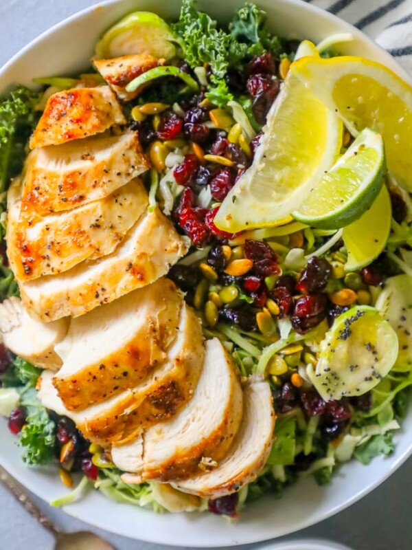 picture of sliced chicken breast over kale salad in a bowl