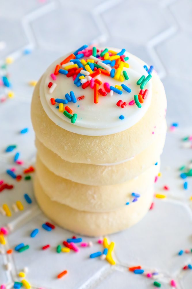 picture of four frosted sugar cookies stacked on top of each other