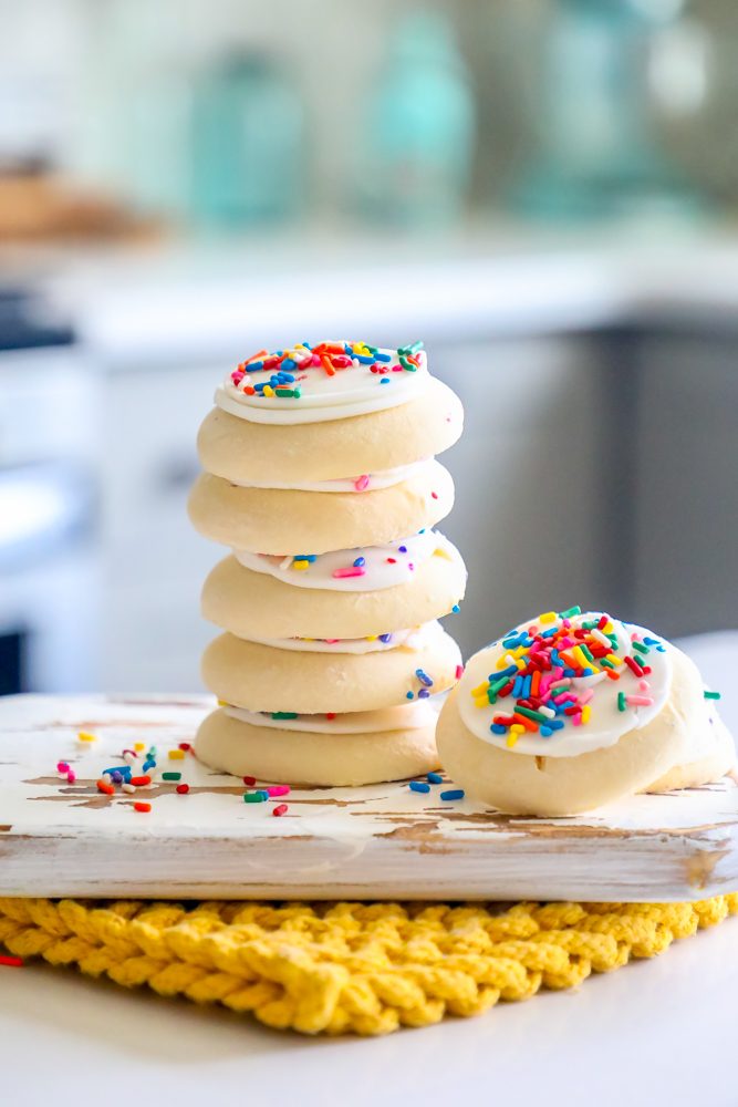 picture of 7 cookies stacked on a cutting board in a kitchen 