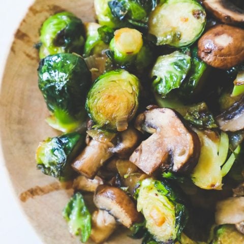 Brussels sprouts and mushrooms on a wooden plate, making brussels sprouts not bitter.