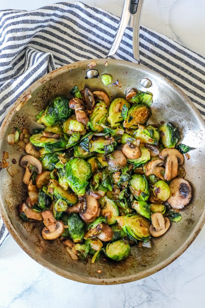 roasted Brussel sprouts and mushrooms in a stainless steel pan