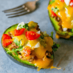 Cheesy Taco Stuffed avocados with tomatoes.