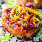 Experience a spicy chicken patty topped with sliced pickles, shredded carrots, and black sesame seeds on a bed of chopped cabbage. It's almost as delightful as an easy salmon burger recipe but with its own fiery twist.
