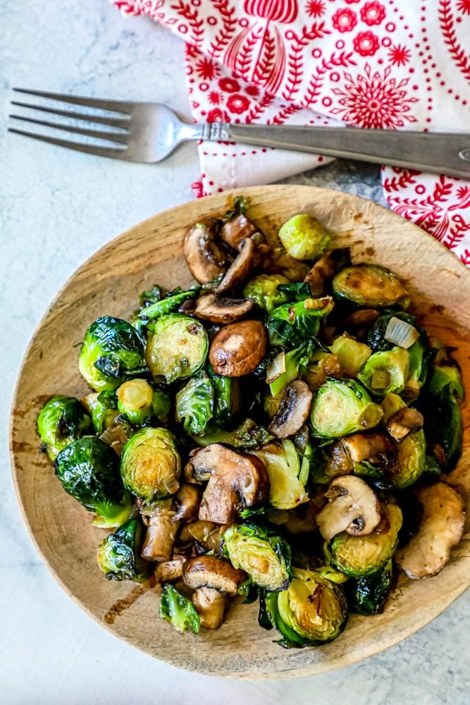 roasted Brussel sprouts and mushrooms on a wooden cutting board