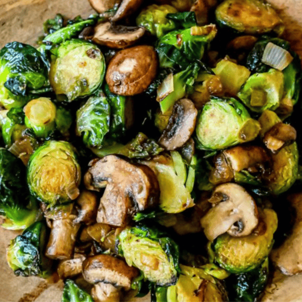 Discover the best Brussels sprouts and mushrooms recipe: perfectly sautéed with onions on a wooden surface.