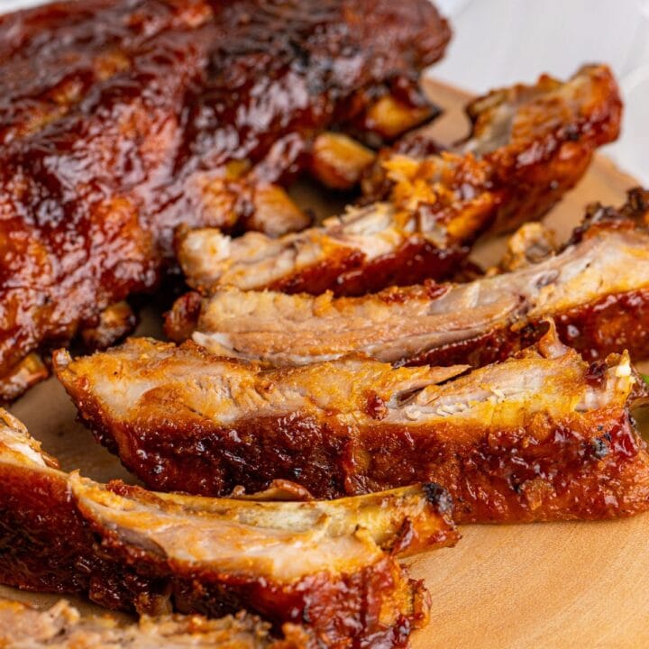 picture of ribs slathered in sauce on a wood platter