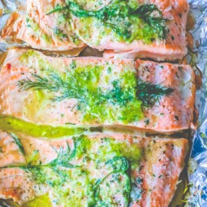 Salmon fillets wrapped in foil with aromatic herbs.
