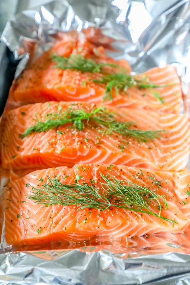 salmon in tin foil with spices and fresh dill on it