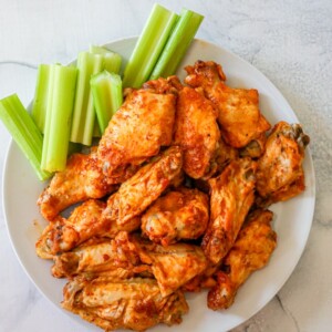 Buffalo wings with celery served on a plate using an easy Instant Pot recipe.