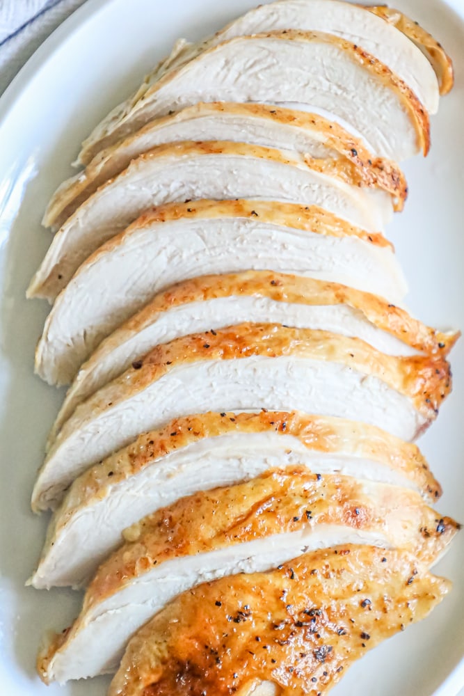 Sliced roasted chicken on a white plate, Oven Baked Turkey Breast.