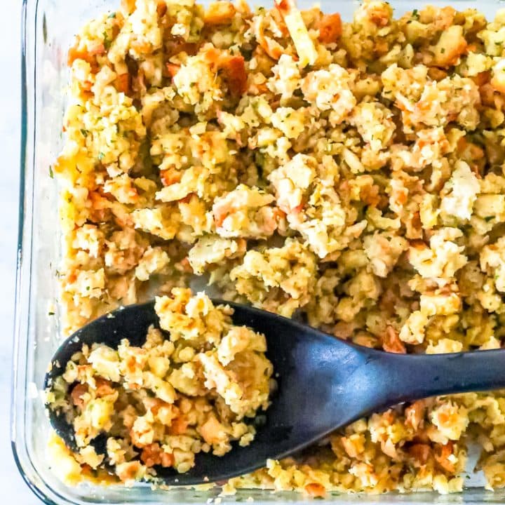 A glass baking dish with a spoonful of Greek Stuffing.
