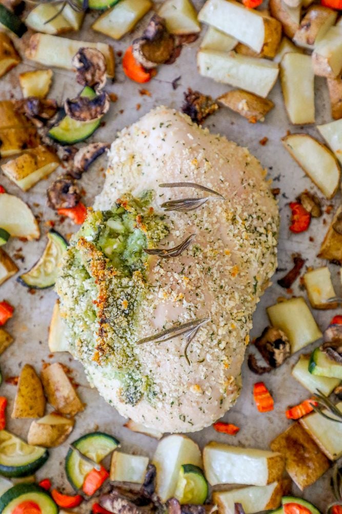 pork loin stuffed with green pesto, zucchini, potatoes, and carrots in the background