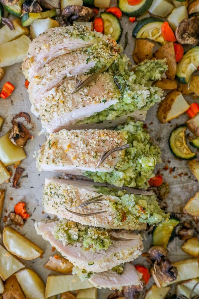 pork loin stuffed with green pesto, zucchini, potatoes, and carrots in the background