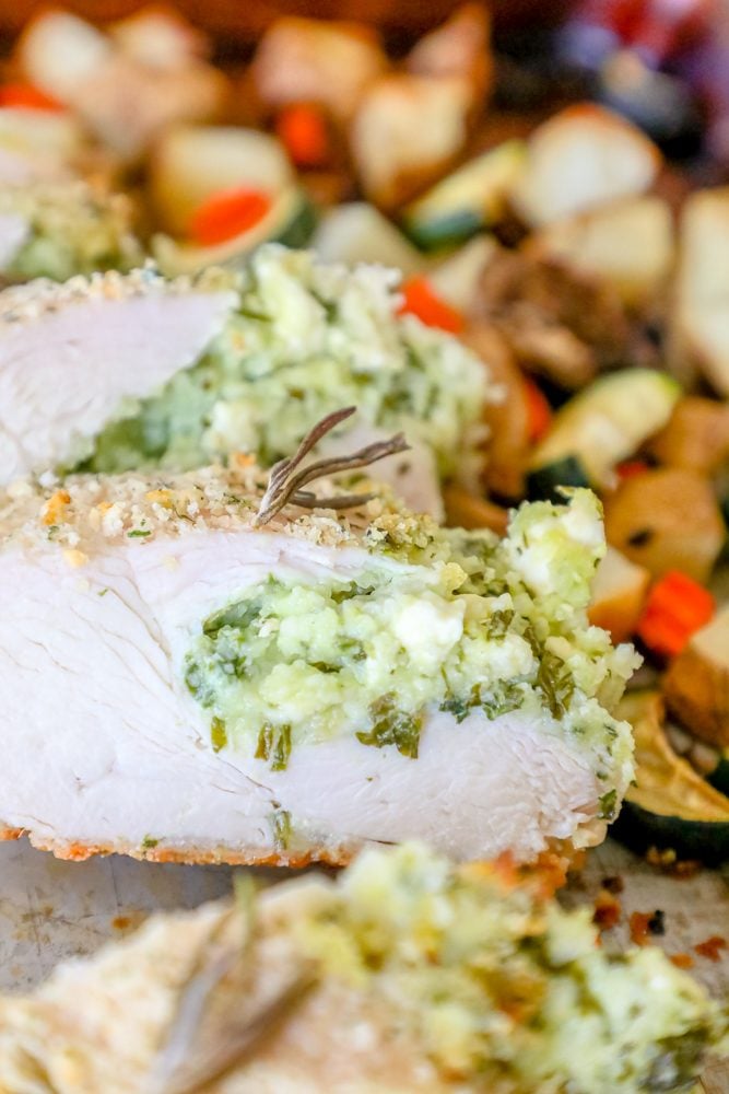 pork loin stuffed with green pesto, zucchini, potatoes, and carrots in the background