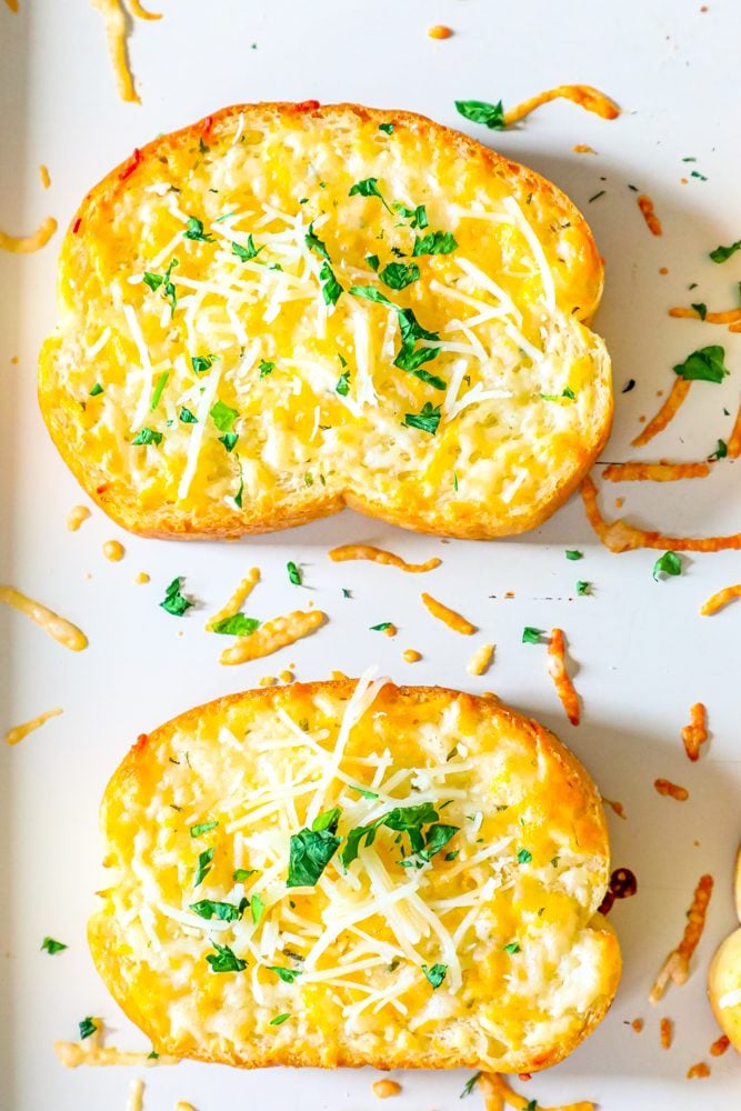 slice of toast on baking sheet with melted cheese on top 