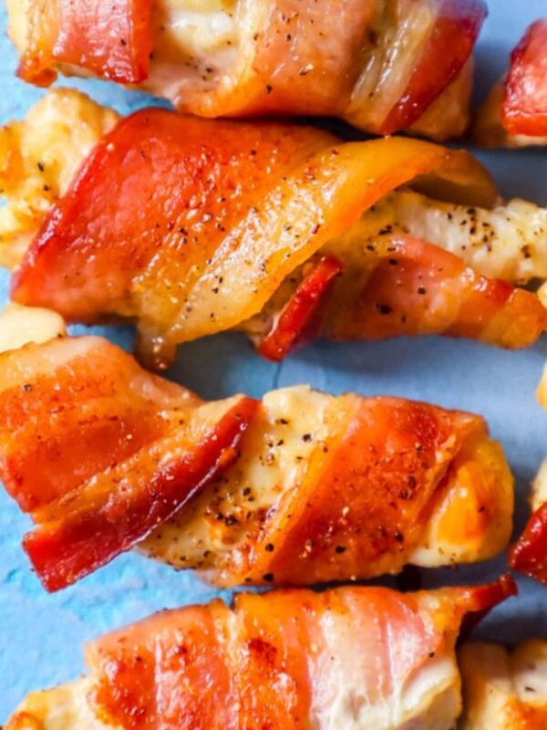 Bacon wrapped chicken skewers on a blue background, with sweet and spicy flavors.