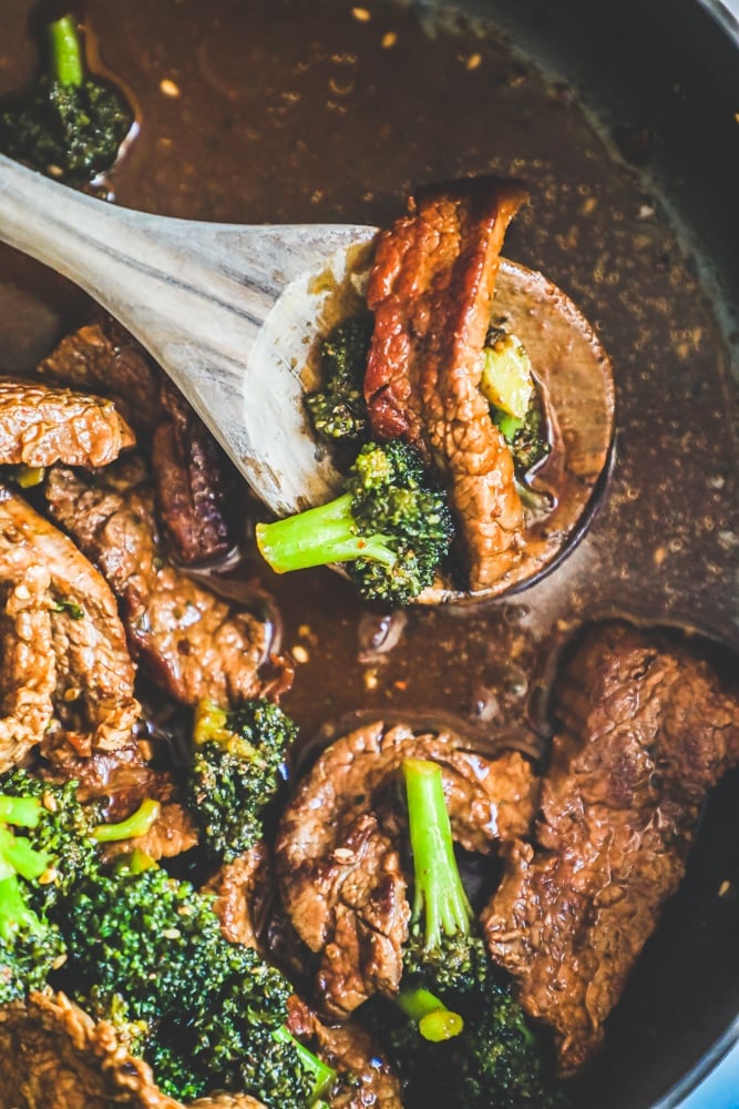 strips of beef, broccoli in a rich sauce. spoon with some meat and broccoli on it